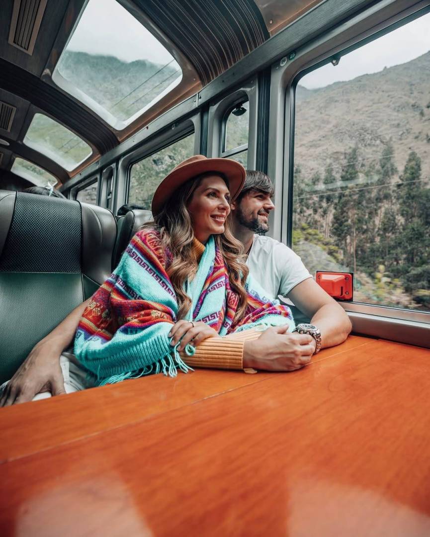 Pareja en un tren panorámico rumbo a Machu Picchu